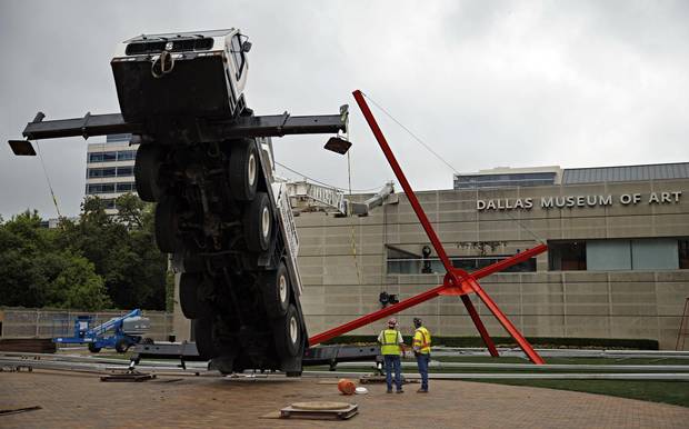 Workers look on at a collapsed crane in front of the Dallas Museum of Art on Friday, April 3, 2015 in Dallas. The crane damaged part of the front of the building, but no injuries were reported. Photo: G.J. McCarthy, Dallas Morning News 