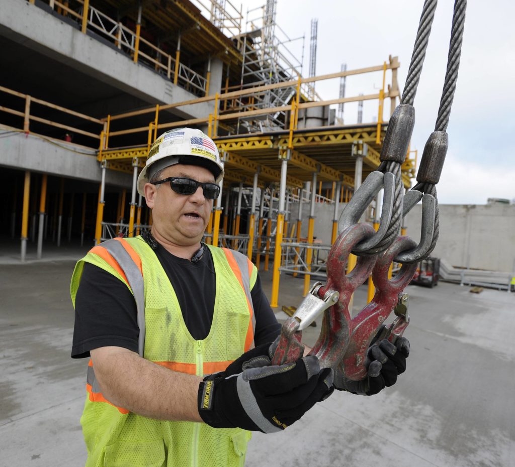 Michael Collins inspects the lifting clamps every morning before he climbs the tower crane. His goal is to protect the men on the ground as he lifts and lowers thousands of pounds of materials above them during each work day.