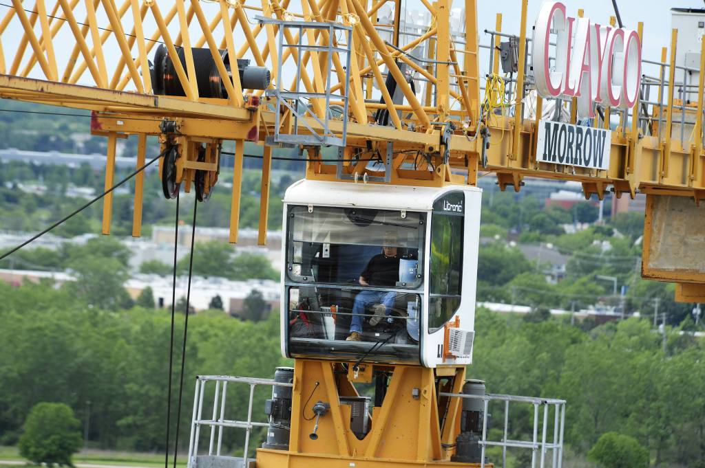Michael Collins sits in the cab of a tower crane on a Schaumburg construction site, moving materials carefully over workers 155 feet below. "It's like a giant video game except there is no reset button," he says.