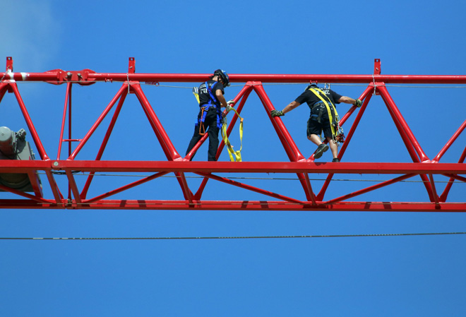 The firefighters walk out on the jib to prepare for the rope rescue drill. (Photo by Eric Albrecht)