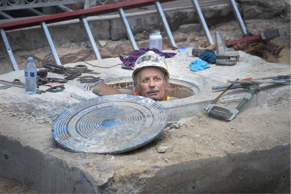 A worker pops up out of a manhole cover in Salt Lake City, Utah. There is currently a shortage of construction workers.